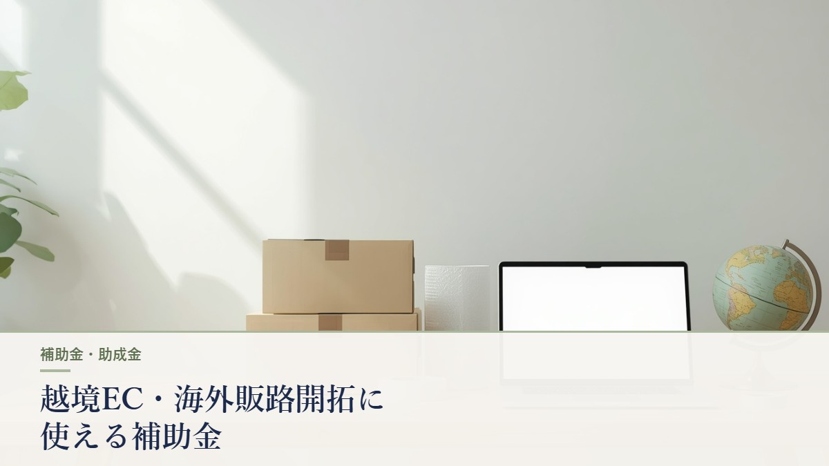 発送用の段ボール箱とノートパソコン・地球儀を置いた作業机｜越境EC・海外販路開拓に使える補助金
