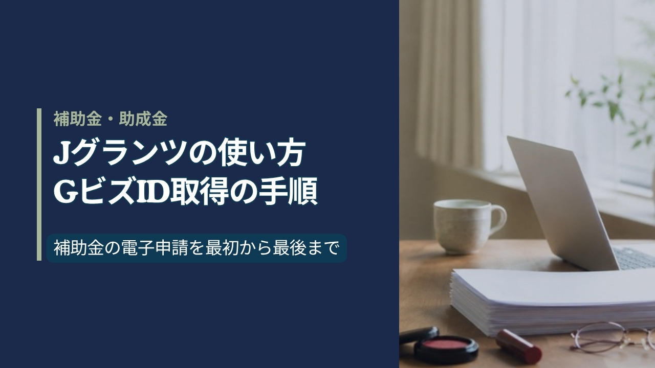 窓辺の机に置かれたノートパソコンとA4の申請書類、朱肉と印鑑|jグランツの使い方とGビズID取得の手順