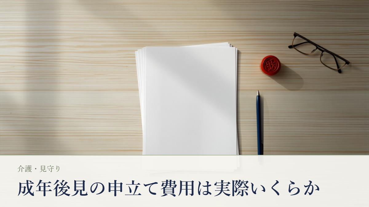 木目のテーブルに広げたA4の申立書類の束と朱肉・印鑑・老眼鏡・ボールペンの静物